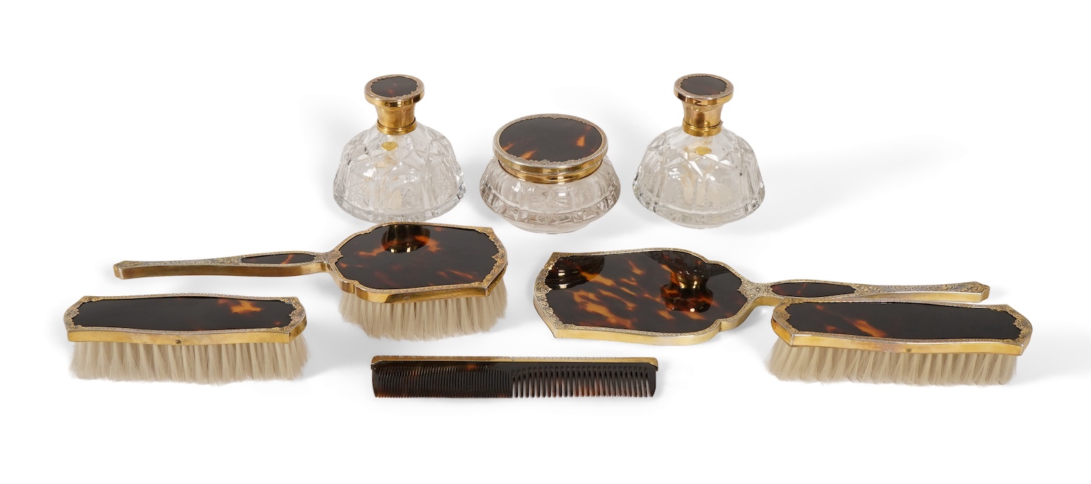 A mid 20th century continental eight piece gilt white metal and tortoiseshell mounted dressing table set